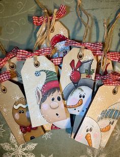 several tags with snowmen on them hanging from twine