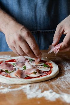 a person kneading ingredients on top of a pizza