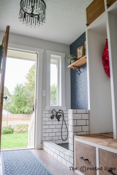 a bathroom with a chandelier hanging from the ceiling and a blue rug on the floor