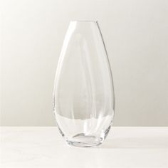 a clear vase sitting on top of a white counter next to a wall and floor