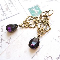 Purple victorian dangle earrings made of purple crystal faceted teardrop drops set in oxidized brass settings and a beautiful oxidized brass ornament. The earwires are made of oxidized brass. The length of the earrings including the hook is approximately 7 cm. (2.8 inches) Crystal: 13 x 18 mm. The oxidized brass components are made in the USA, most pieces are stampings made of antique dies from the 19th century. They are oxidized for a lovely antique bronze patina and durability. For more jewelr Brass Ornament, Brass Components, Victorian Earrings, Brass Ornaments, Bronze Patina, Earrings Purple, Purple Rhinestone, Purple Crystal, Purple Crystals