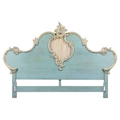 a blue headboard with an ornate design on it's frame and foot board