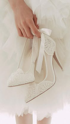 a close up of a person's shoe with a bow on the heel and white dress