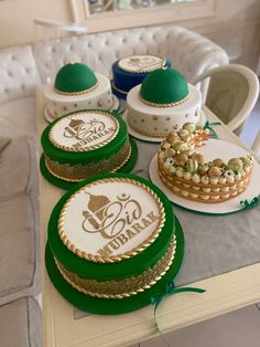 a table topped with plates and cakes covered in frosting next to a white couch