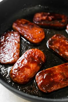 some sausages are cooking in a skillet