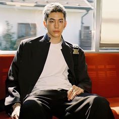 a young man sitting on top of a red couch