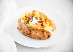 a white plate topped with a loaded baked potato