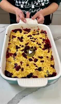 a person is holding a casserole dish with berries