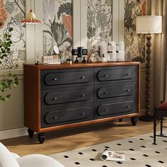 a dresser with many items on top of it in front of a wallpapered room