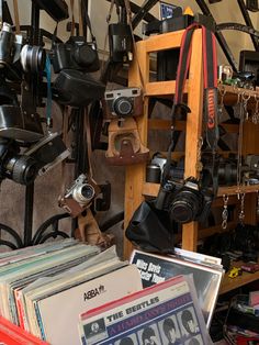 a room filled with lots of different types of cameras and records on shelves next to each other