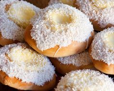 four donuts on a white plate with powdered sugar and jelly in the middle