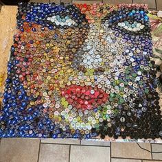 there is a large amount of bottle caps laid out on the floor to look like a cat