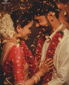 a man and woman standing next to each other with confetti falling around them