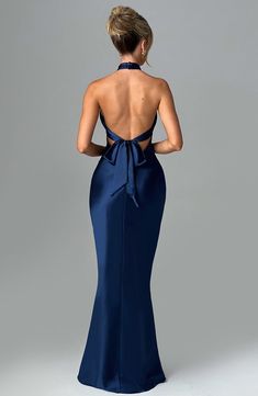 Feel opulent in Dimitra, a stunning maxi design crafted in delicate satin with a beautiful sheen and silky soft feel. Featuring a high cross over neckline and low back with tie detail, this style has a fit and flare silhouette and flattering piping under the bust. Keep things chic with barely there heels and sleek hair. 



Colour: Navy.

Premium non-stretch satin.

Shaped piping under bust.

Fit and flare silhouette.

High cross over neckline.

Tie detail to back.

Low back.

Invisible zipper t Luxury Maxi Length Gown With Tie Back, Luxury Fitted Blue Satin Dress, Luxury Blue Fitted Satin Dress, Luxury Fitted Bodice Backless Gown, Luxury Blue Dresses With Flattering Silhouette, Luxury Gown With Tie Back And Fitted Bodice, Luxury Fitted Bodice Low Back Gown, Luxury Backless Strapless Dress With Fitted Bodice, Luxury Tie Back Maxi Gown