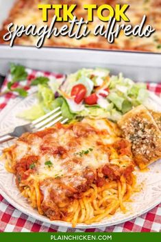 a white plate topped with lasagna next to a salad