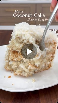 a white plate topped with a cake covered in coconut frosting and a bite taken out of it