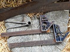 an old pair of shears laying on top of a rock next to some scissors