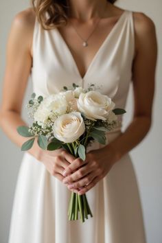 a woman in a white dress holding a bouquet of flowers