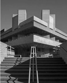 black and white photograph of stairs leading up to an architectural building with concrete steps in front