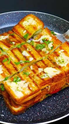 a grilled sandwich with cheese and herbs on a plate