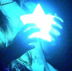 a person holding a glowing star in their hands