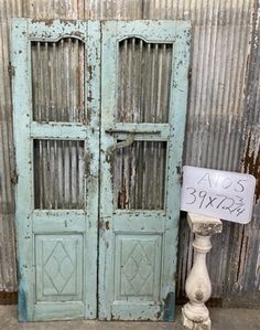 an old blue door with a sign on it