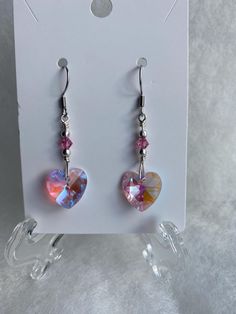 MADE IN MONTANA. I just ❤️ love these earrings! They are dangly crystal hearts that are clear but shiny! They are made with non tarnish wire, Sterling silver beads, pink bicones. and pink colored crystal hearts. These are a fun gift for anyone. Have fun with these pretties!  SIZE-  These are 2 inches long from the top to the bottom of the heart crystal. JEWELRY CARE- As with all jewelry, you want to keep it as nice as the day you received it. Please do not wear in the shower, sleep in , wear wor Pink Heart Crystal, Pink Heart Earrings, Business Product Ideas, Beaded Earrings Diy, Earrings To Make, Silver Heart Earrings, Heart Crystal, Earrings Diy, Earrings Crystal