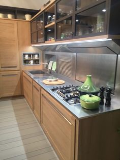 a kitchen with wooden cabinets and stainless steel counter tops, including a stove top oven