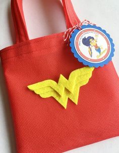 a red tote bag with a yellow bird on the front and a blue ribbon around it