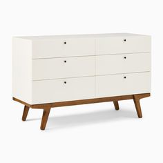 a white dresser with wooden legs and drawers