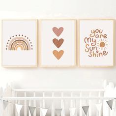 three prints on the wall above a crib