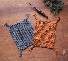 two crocheted cushions sitting on top of a wooden table