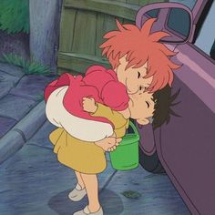 two children are kissing in front of a car