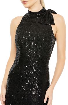 Get your glow on with a sequin-showered gown, done in a close fit and accented with a bow detail gracing a single shoulder. 62 1/2" length Halter neck Sleeveless, with cutaway shoulders Lined 100% polyester Spot clean Imported Black Tie Gowns, Evening Gowns Online, Sheath Gown, Wedding Guest Style, Column Skirt, Tie Neck Dress, Mac Duggal Dresses, Unique Prom Dresses, Sleeveless Gown