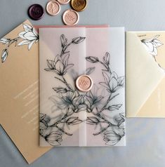 two cards with wax stamping on them next to some envelopes and money coins