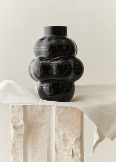 a black vase sitting on top of a white table