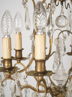 a chandelier with three candles and several crystal drops on the bottom one light