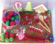 a plastic container filled with assorted christmas decorations and other holiday decorating items, including pom poms