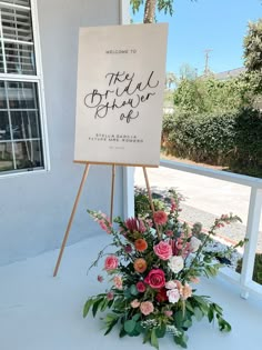 a sign that is sitting on a table with flowers in front of it and the words welcome to the beautiful flower shop