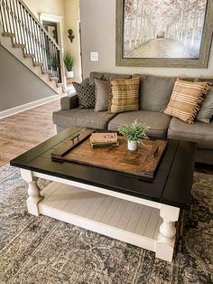 a living room with a couch, coffee table and stairs