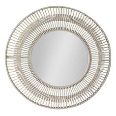 the round mirror is made from rattan and has a white frame with silver trim