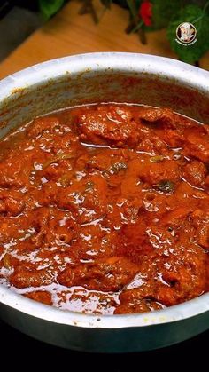 a pot filled with meat and sauce on top of a table