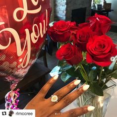 a woman's hand holding a bouquet of red roses with the words i love you written on it