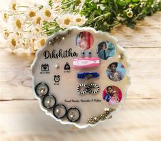 a white plate topped with lots of different types of hair clips and earrings next to flowers