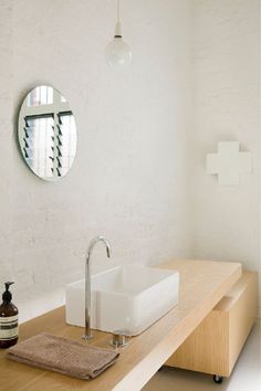 a bathroom with a sink, mirror and soap dispenser on the counter