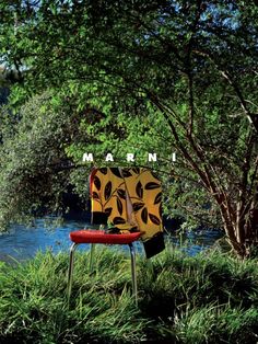 a red chair sitting on top of a lush green field