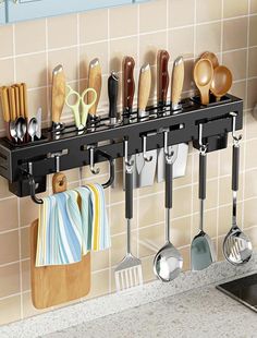 there is a rack with utensils hanging on the wall in the kitchen,