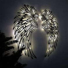 two angel wings are lit up in the dark