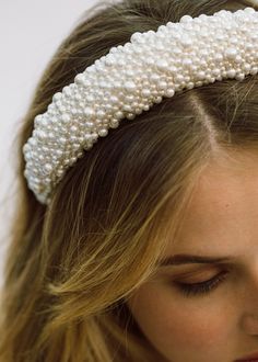 a woman wearing a headband with pearls on it