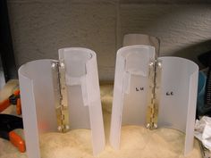 three white glass vases sitting next to each other on top of a countertop